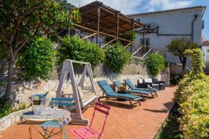 a group of chairs and tables on a patio at Villa Donna Antonia - Amalfi Coast in Conca dei Marini