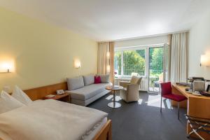una camera d'albergo con un letto e un divano di Hotel Bad Ramsach a Läufelfingen