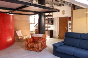a living room with a chair and a couch at La Corte di Brusuglio Apartments in Cormano