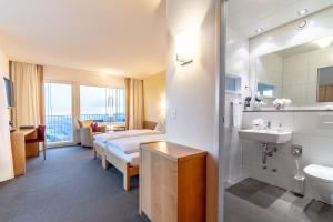 una camera d'albergo con un letto e un lavandino di Hotel Bad Ramsach a Läufelfingen