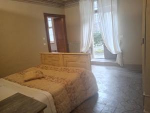 a bedroom with a bed and a large window at Casa vialardi in Brusasco