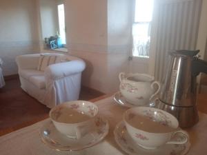 two cups and saucers on a table with a coffee maker at Casa vialardi in Brusasco