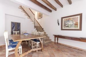 a dining room with a wooden table and stairs at Mallorca One in Pollença