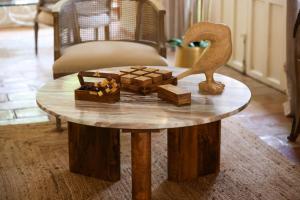 a wooden table with a statue on top of it at Hôtel La Villa Sainte Valérie Adults Only in Juan-les-Pins