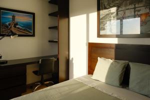 a bedroom with a bed and a desk and a window at Casa Horizontes de Arouca in Arouca