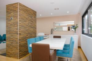 a dining room with a white table and blue chairs at Casa Horizontes de Arouca in Arouca