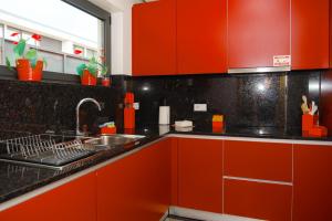 a kitchen with red cabinets and a sink at Casa Horizontes de Arouca in Arouca