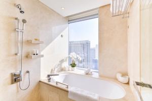 a bathroom with a bath tub and a window at Emaar Dubai Marina Residences - formerly Address Dubai Marina in Dubai