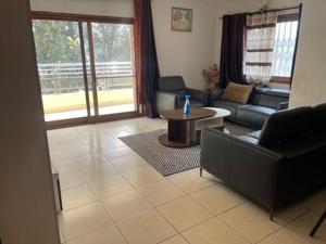ein Wohnzimmer mit einer Couch und einem Tisch in der Unterkunft Appartement Familial Confortable in Conakry