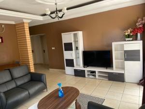 ein Wohnzimmer mit Couch und Fernseher in der Unterkunft Appartement Familial Confortable in Conakry