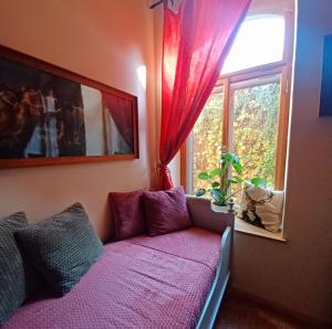 a purple couch in a room with a window at Ferienwohnung ANTIK in Gotha
