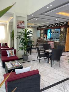 a lobby with chairs and tables and a bar at فندق عين دره in Sawdāʼ