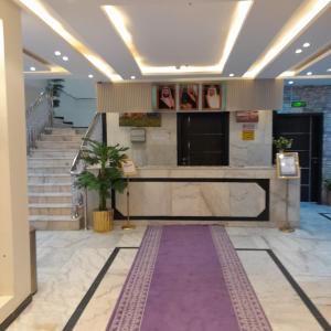 a lobby with stairs and a purple carpet at فندق عين دره in Sawdāʼ