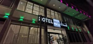 a sign on the side of a building with green lights at فندق عين دره in Sawdāʼ