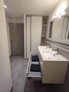 a white bathroom with two sinks and a counter at Appartement 64m2 in Ambérieu-en-Bugey