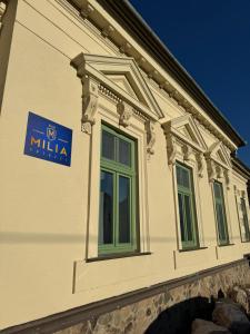 a building with a blue sign on the side of it at Villa MILIA in Bátovce