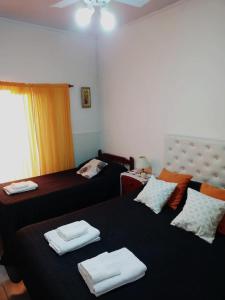a bedroom with two beds with towels on them at LOS GURISES Villa Elisa in Villa Elisa