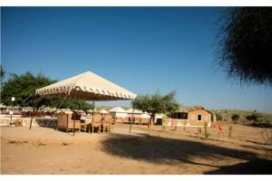 a tent on the beach with tables and chairs at The Ker desert camp in Jaisalmer
