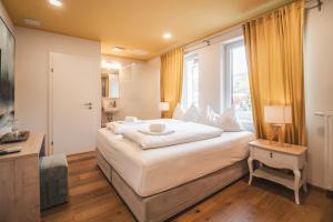 a bedroom with a large bed and a window at Boutiquehotel Caravella Velden by S4Y in Velden am Wörthersee