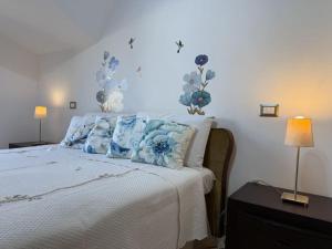 1 dormitorio con 1 cama con flores azules en la pared en Premium Sofy & Bea Home - 25 minuti da Roma Centro, en Albano Laziale