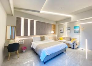 a hotel room with a large bed and a couch at MUMU Villa in Hengchun