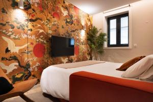 a bedroom with a bed and a tv on a wall at Byobu Apartment, by Bolhão Residences in Porto