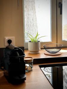 a coffee maker on a kitchen counter with a window at Studio centre historique - climatisé in Pézenas +4 photos