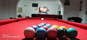 ein roter Billardtisch mit einer Spielkugel darauf in der Unterkunft Casa do pé de Jabuticaba in Guarujá