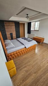 a large bed in a room with a wooden floor at ELISA Rooftop Luxury Apartments in Skopje