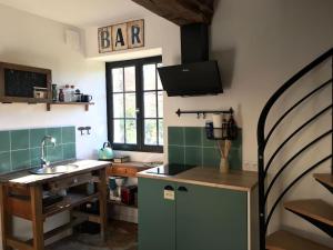 a kitchen with a sink and a bar sign on the wall at Maison avec cour L'atelier in Couchey