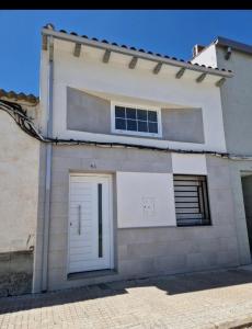 una casa con una porta bianca sul lato di Casa Amador a Hinojosa del Duque