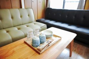 a living room with a table and a couch at Oyado HALUBALL in Takayama