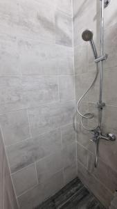 a shower with a shower head in a bathroom at new 2 room in Bălţi