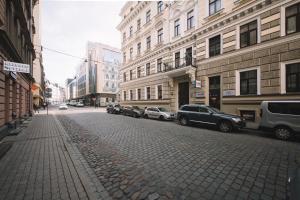 a city street with parked cars and buildings at Photographer Rudolf's Studio - ground floor with separate entrance in Rīga