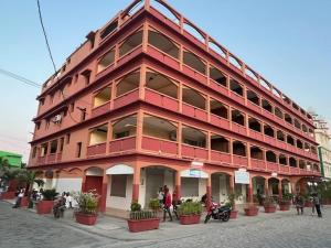 a red building with people standing outside of it at HOTEL MENABE in Morondava