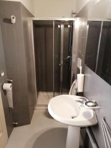 een kleine badkamer met een wastafel en een douche bij Appartamento Teatro Duse in Bergamo +6 foto's