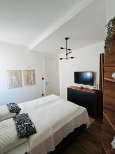 a bedroom with a bed and a flat screen tv at Harmony Peak Jahorina in Jahorina