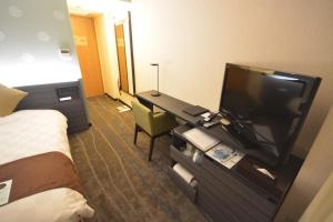 a hotel room with a television and a bed at Takamatsu Tokyu REI Hotel in Takamatsu