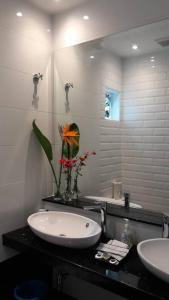 Un baño con un lavabo y un jarrón de flores. en Rose Hill Gardens, en Brinchang