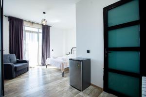 una camera con un letto e una porta con una sedia di Level Up Hotel & Restaurant a Kobuleti