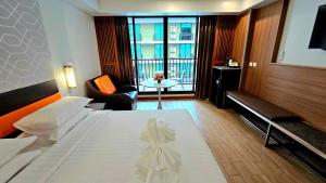 a hotel room with a large bed and a table at Dynasty Grande Hotel in Bangkok +45 photos