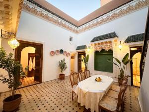 a dining room with a table and chairs and a chalkboard at Riad M Azbetz in Marrakech