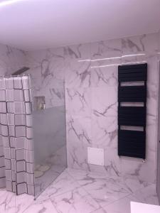 a bathroom with white marble walls and a piano at Appartamento Tortona in Tortona