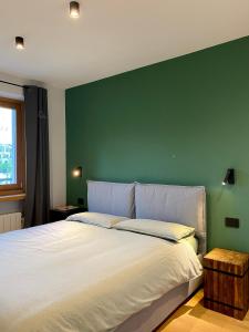 a bedroom with a large bed with a green wall at La Primula in Pragelato