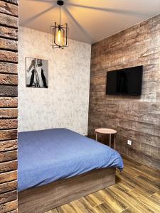 a bedroom with a bed and a flat screen tv at Apartments Black Sea in Odesa