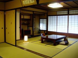 Cette chambre comprend une table et une lampe. dans l'établissement Inn Kawashima, à Kyoto