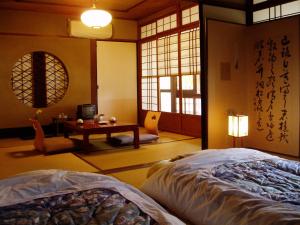 a bedroom with a bed and a table and window at Inn Kawashima in Kyoto