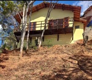 une maison sur une colline avec des arbres devant elle dans l'établissement Flor da serra, à Santo Antônio do Pinhal