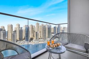 a balcony with a table and chairs and a view of a city at EDEN'S Homes & Villas - VIDA Dubai Marina Residences in Dubai