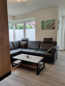 Una sala de estar con un sofá y una mesa de café. en Haus Albatros EG - Exklusive Fewo für 4 Personen, en Dangast